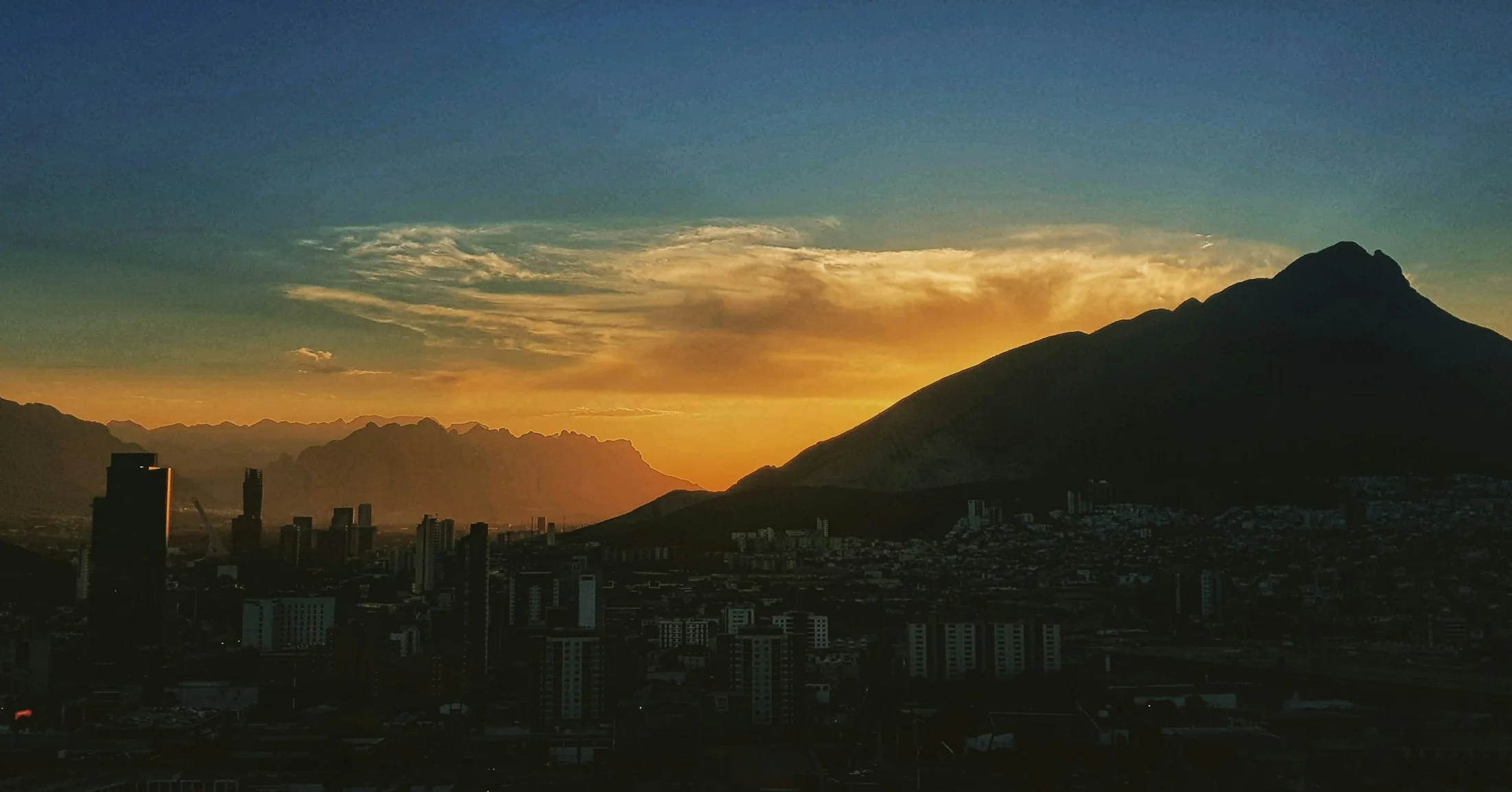 Silueta de Monterrey y sus montañas durante un atardecer dorado